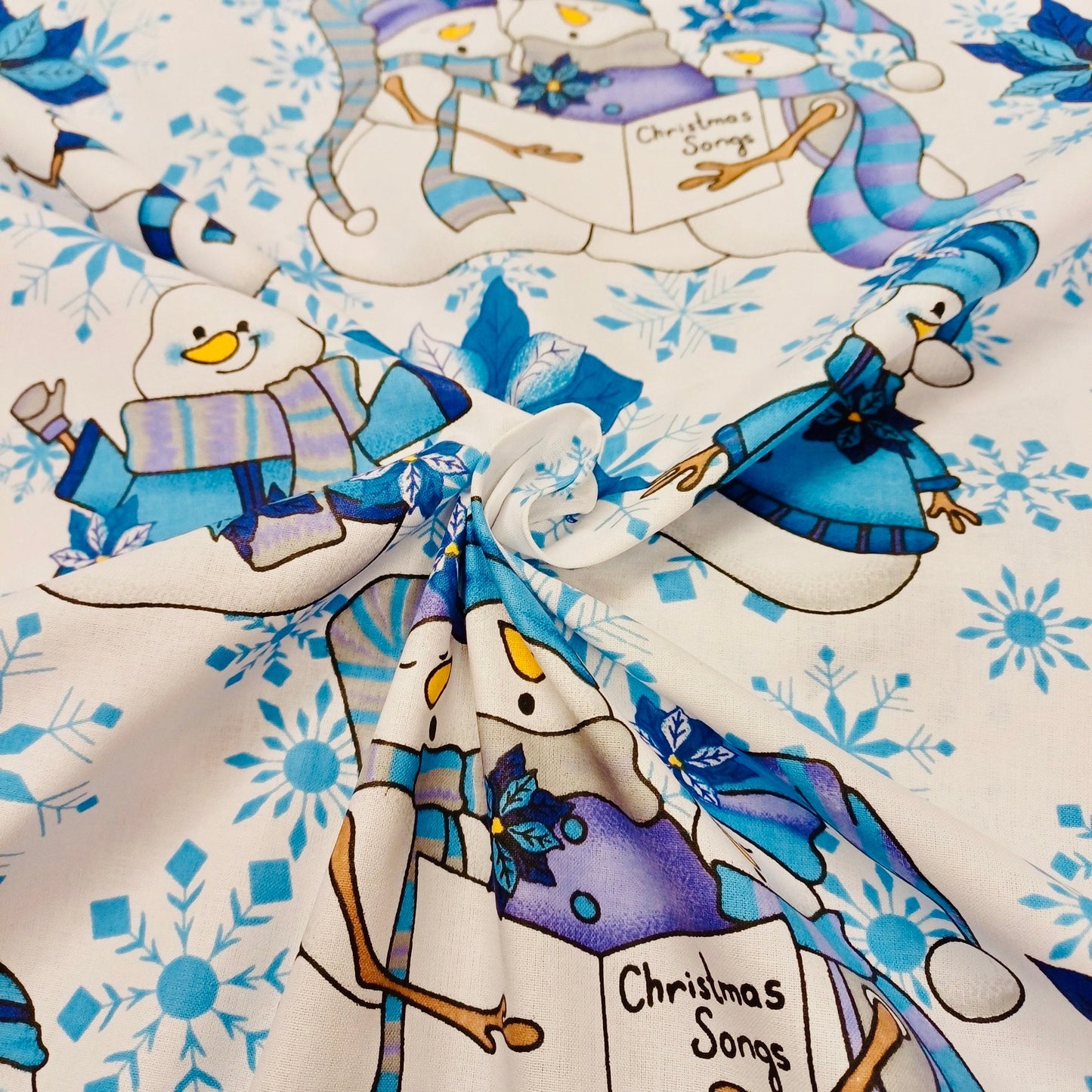 Tissu 100 % coton - bonhomme de neige avec chapeau bleu sur fond blanc 130 g/m²