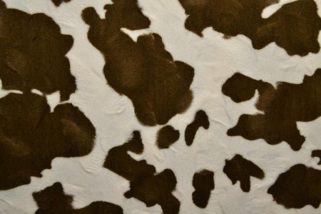 Image de fausse fourrure à motif vache – marron/blanc – disponible en ligne chez Charlotte’s Fabrics