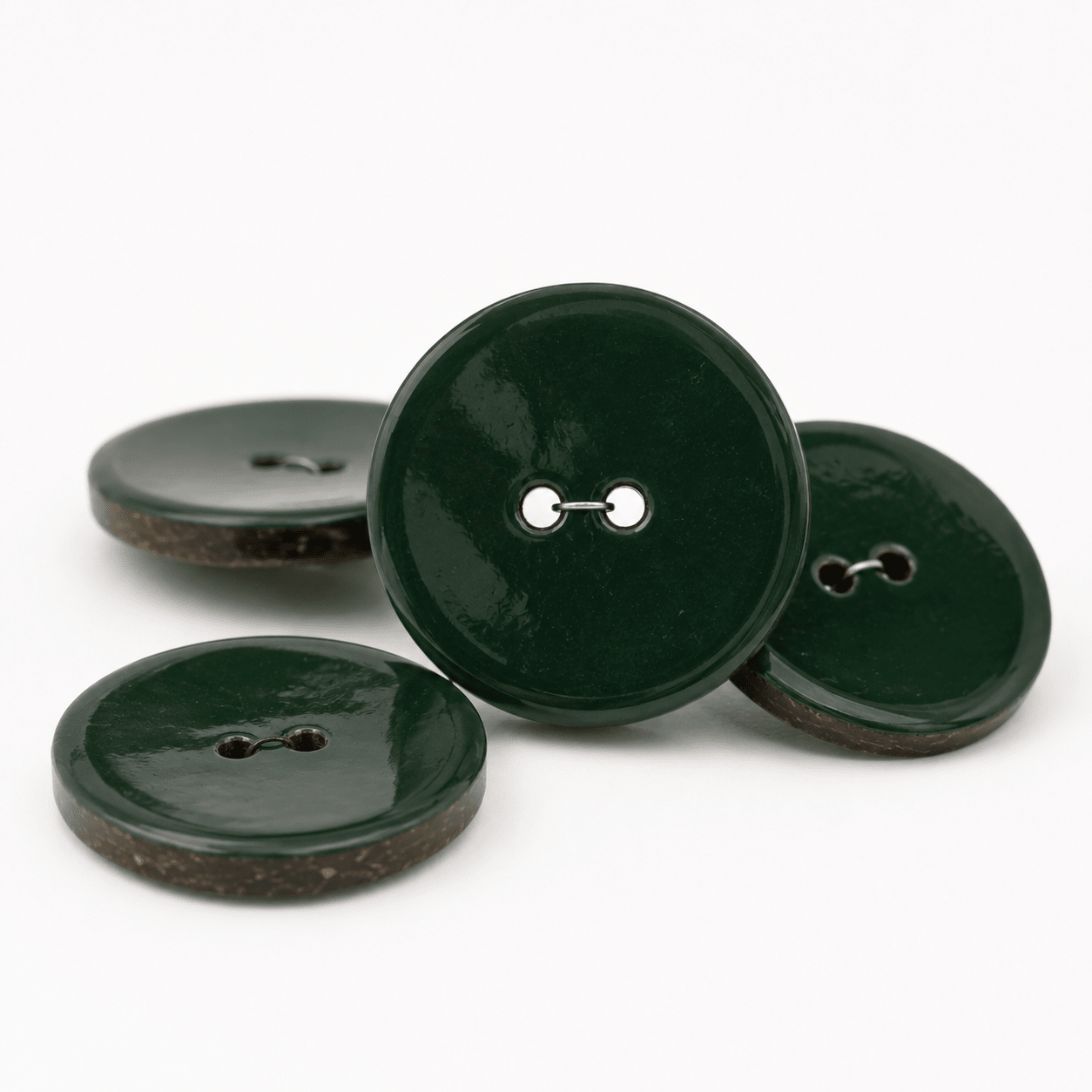 Image of a dark green enamel-coated coconut button – 40 mm – available online at Charlotte’s Fabrics