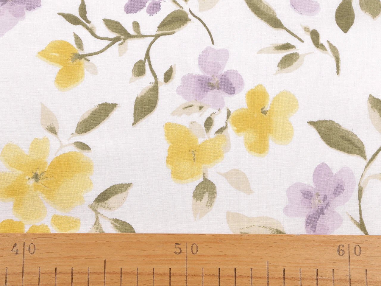 Bild mit 100 % Baumwollstoff mit gelben und lila Blumen – online erhältlich bei Šarlotes audumi