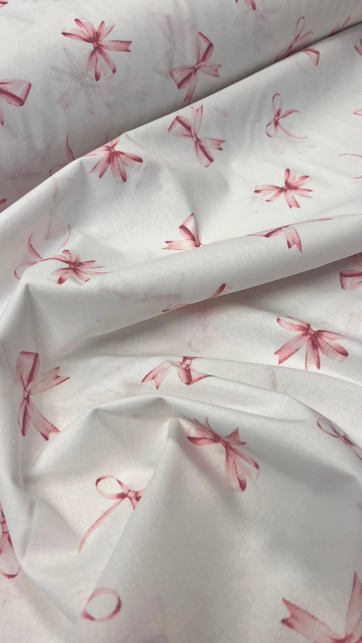 Image of 100% cotton fabric with pink bows – available online at Šarlotes audumi