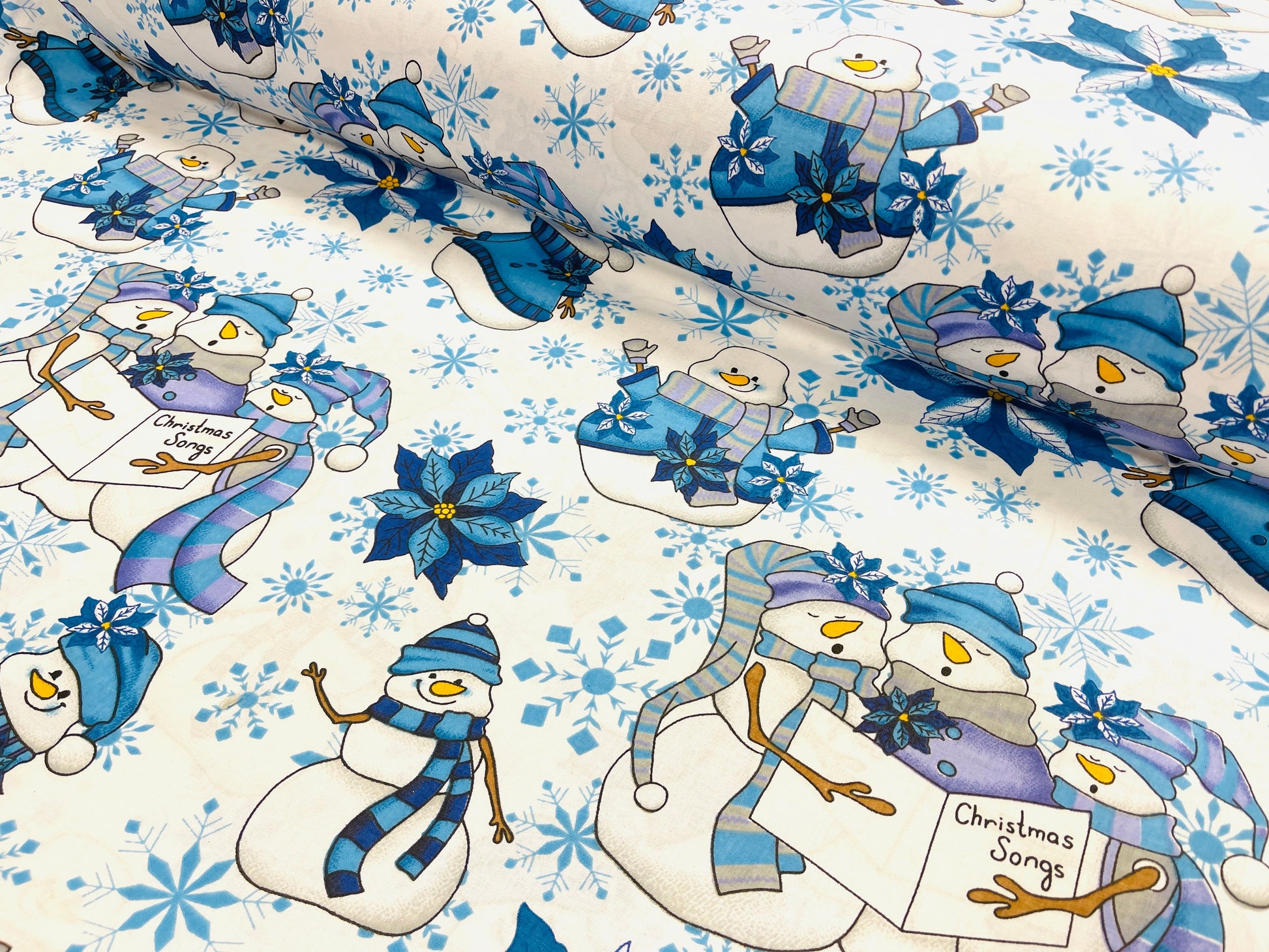 Tissu 100 % coton - bonhomme de neige avec chapeau bleu sur fond blanc 130 g/m²