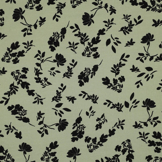 Image d’un tissu 100 % viscose à fleurs blanches sur fond vert pistache, 110 g/m² – disponible chez Šarlotes audumi