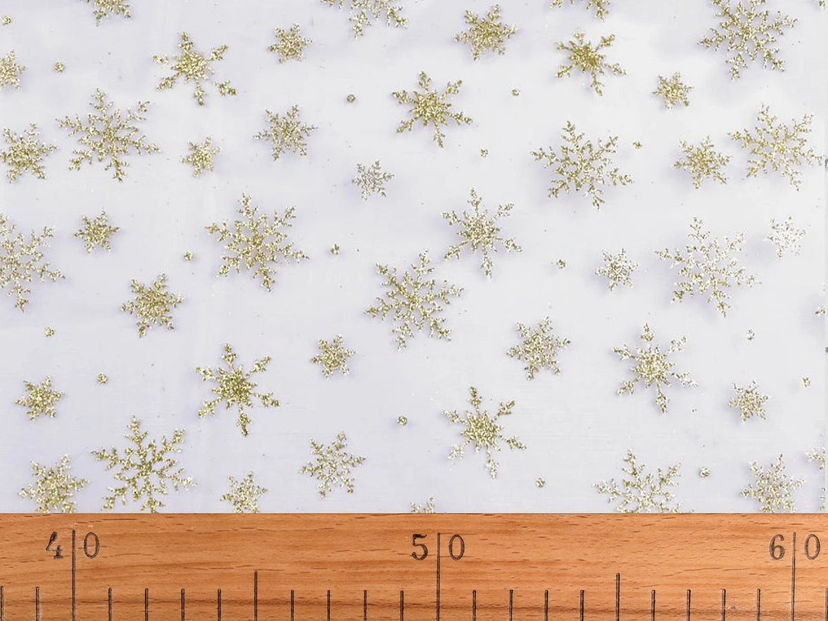 Image d’organza blanc aux flocons de neige dorés scintillants – disponible en ligne chez Tissus de Charlotte