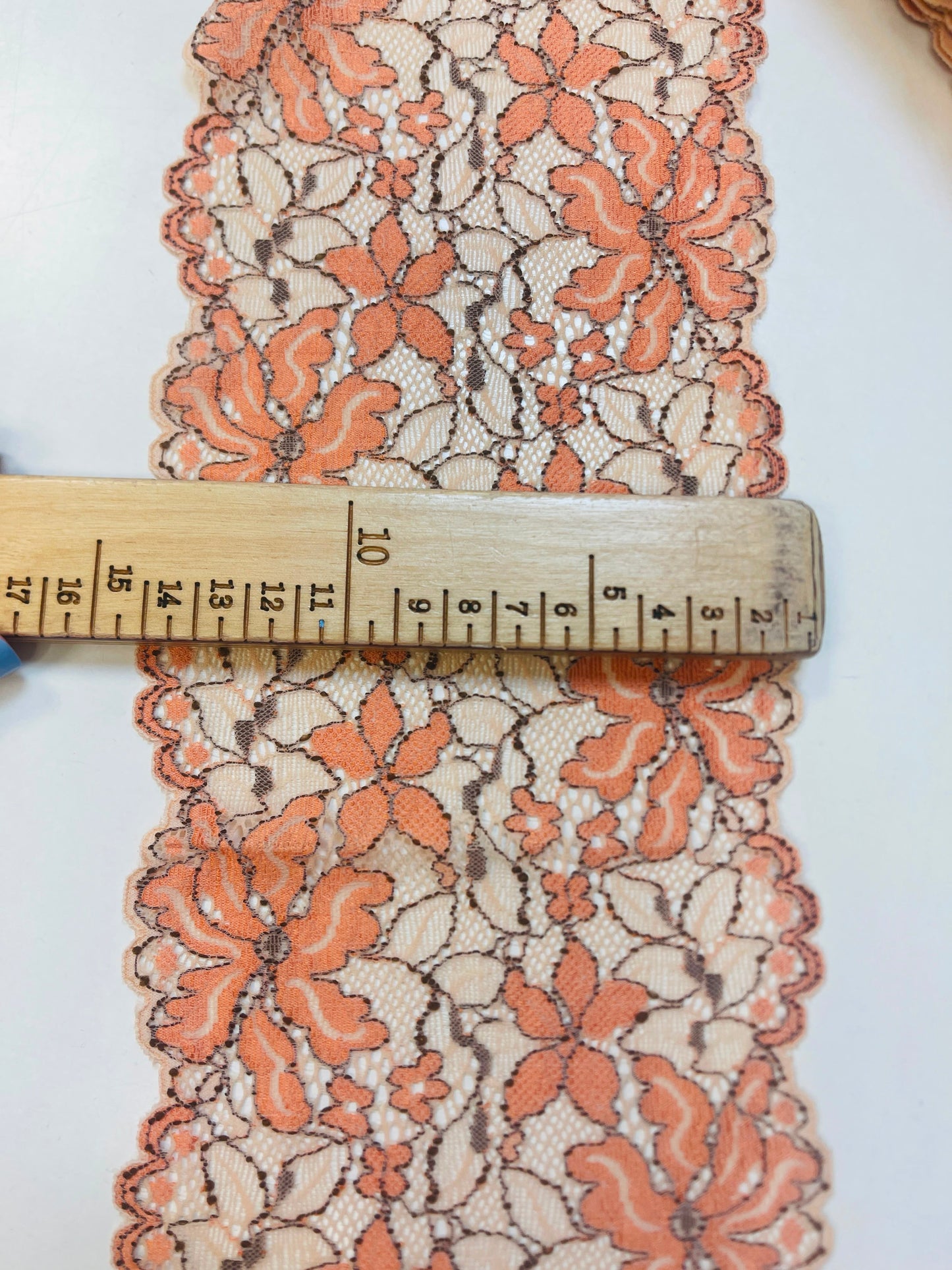 Image with 14 cm elastic lace, orange flowers and beige base – available online at Šarlotes audumi