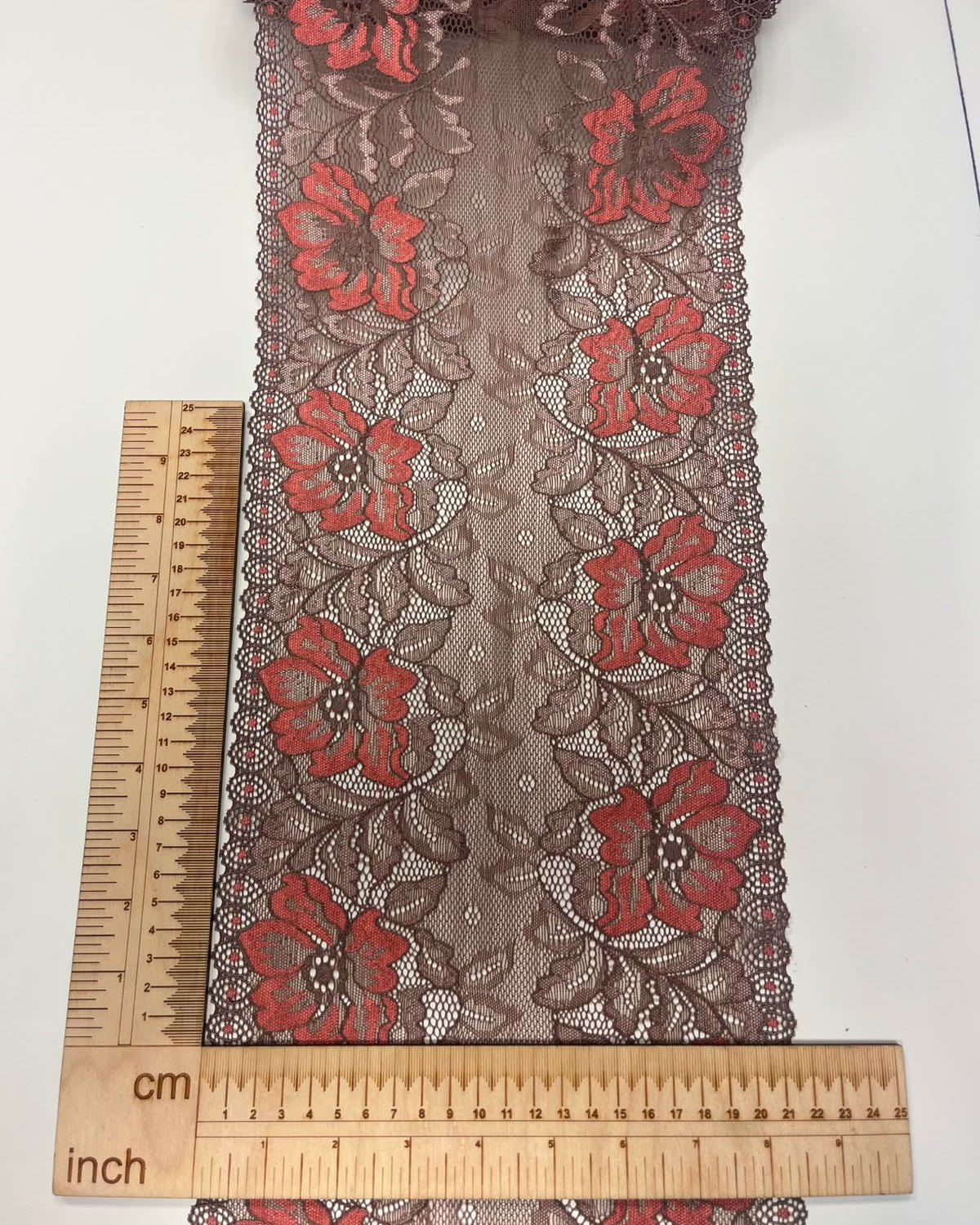 Image with elastic lace, 22 cm, brown with orange flowers – available online at Šarlotes audumi
