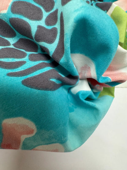 Image of French fabric with a tropical floral pattern in teal tones – available online at Charlotte's Fabrics