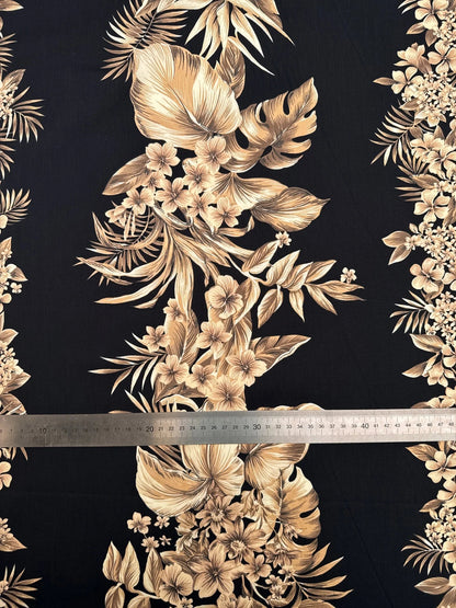 Image d’un tissu en coton italien à motif floral tropical sur fond noir – disponible en ligne chez les tissus de Charlotte