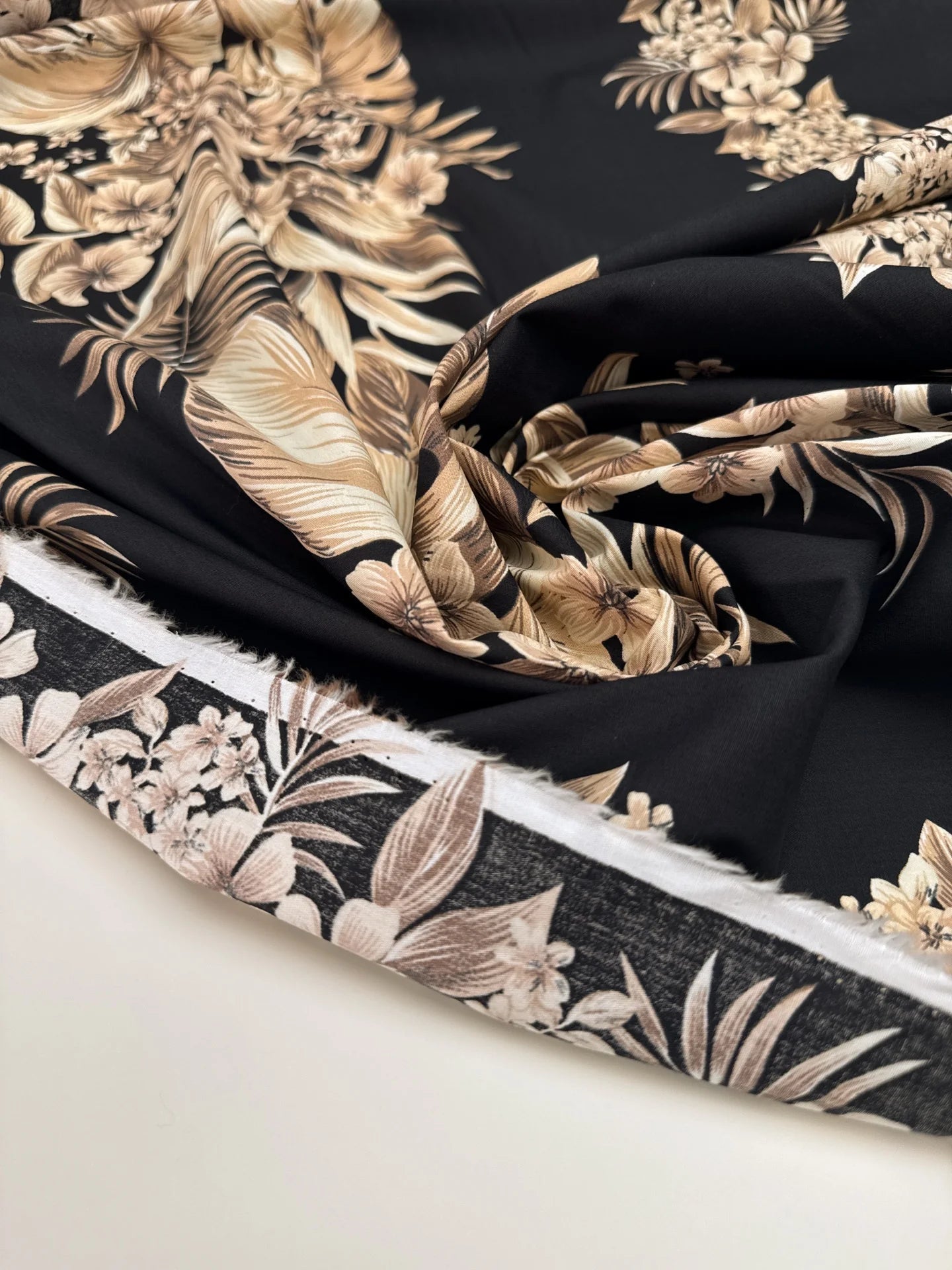 Image d’un tissu en coton italien avec motif floral tropical sur fond noir – disponible en ligne chez Šarlotes audumi