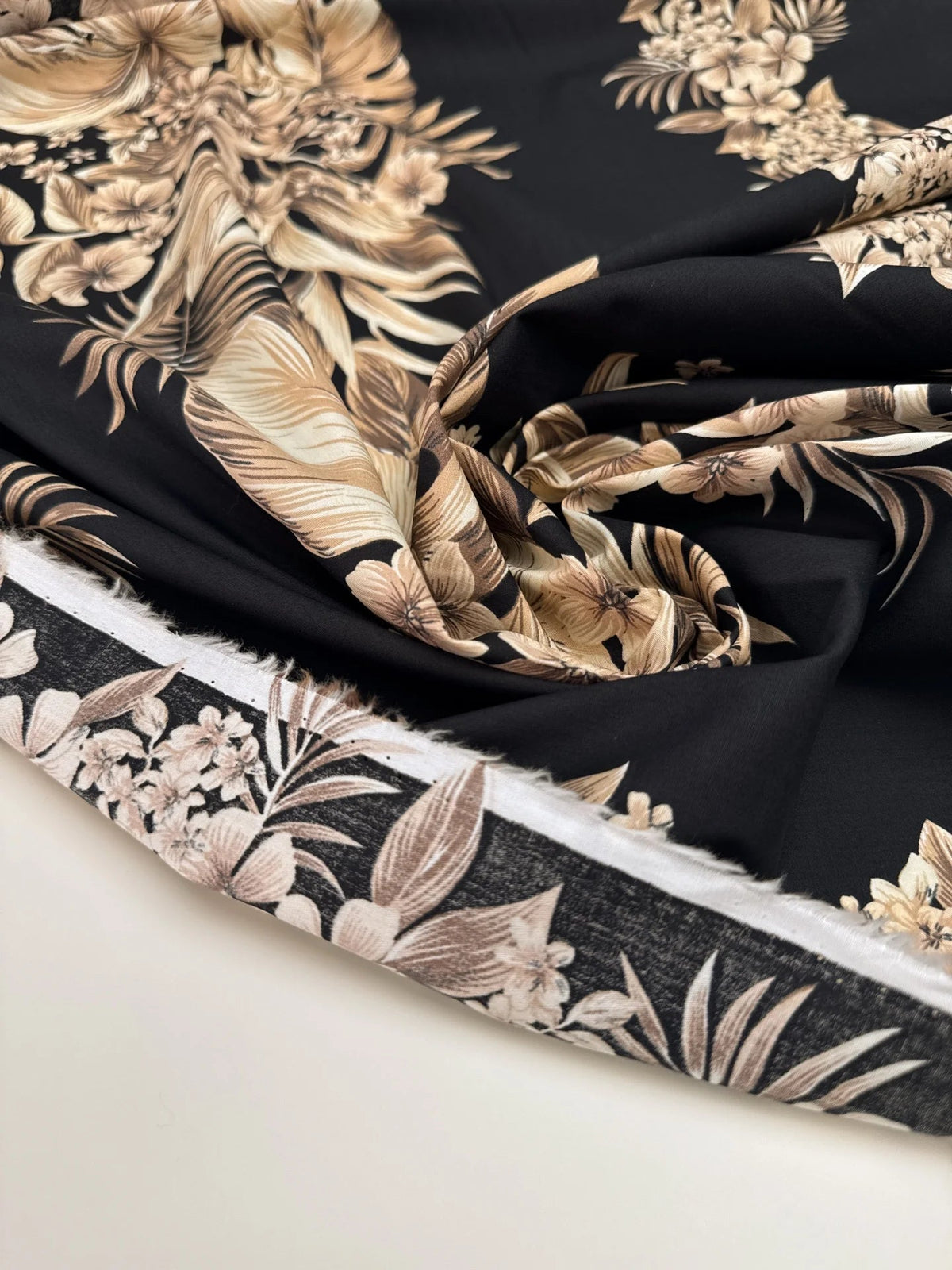 Image d’un tissu en coton italien avec motif floral tropical sur fond noir – disponible en ligne chez Šarlotes audumi