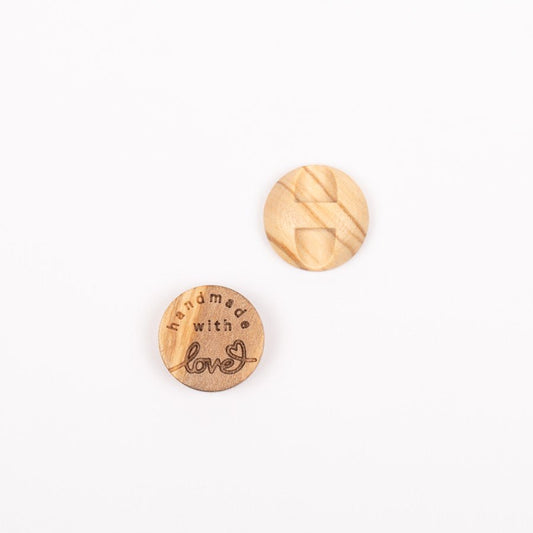 Image d’un bouton en bois d’olivier Handmade with love 15 mm – disponible en ligne chez Šarlotes audumi
