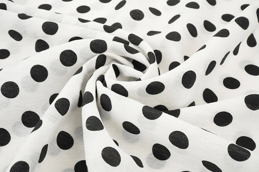 Image of viscose fabric with black circles on white, 80 g/m² – available at Šarlotes audumi