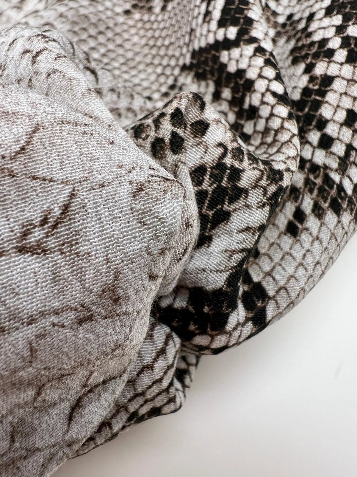 Image d’un tissu crêpe de viscose à motif peau de serpent, tons beige – Italie – disponible en ligne chez Šarlotes audumi