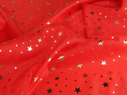 Image d'un tissu décoratif de Noël à étoiles dorées, disponible en ligne chez Šarlotes audumi