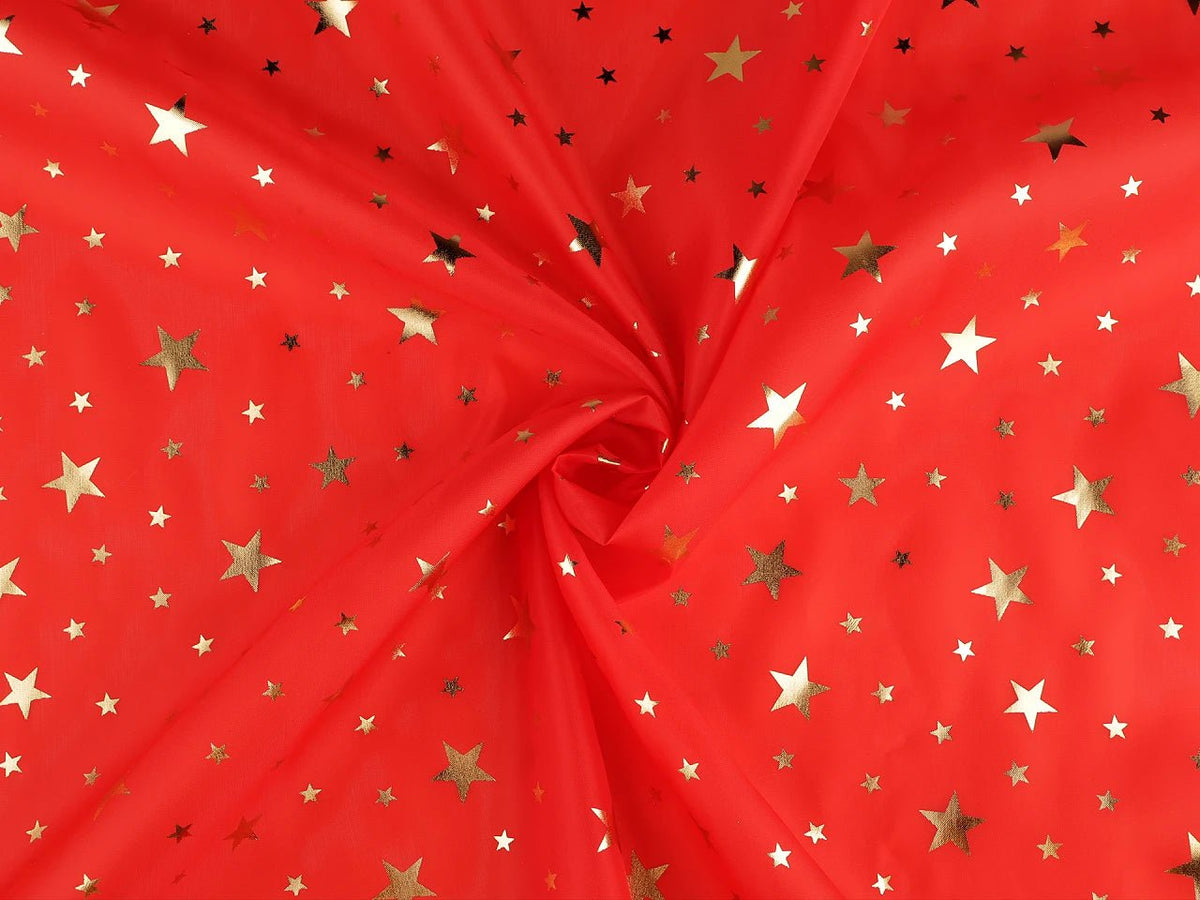 Image d'un tissu décoratif de Noël à étoiles dorées, disponible en ligne chez Šarlotes audumi