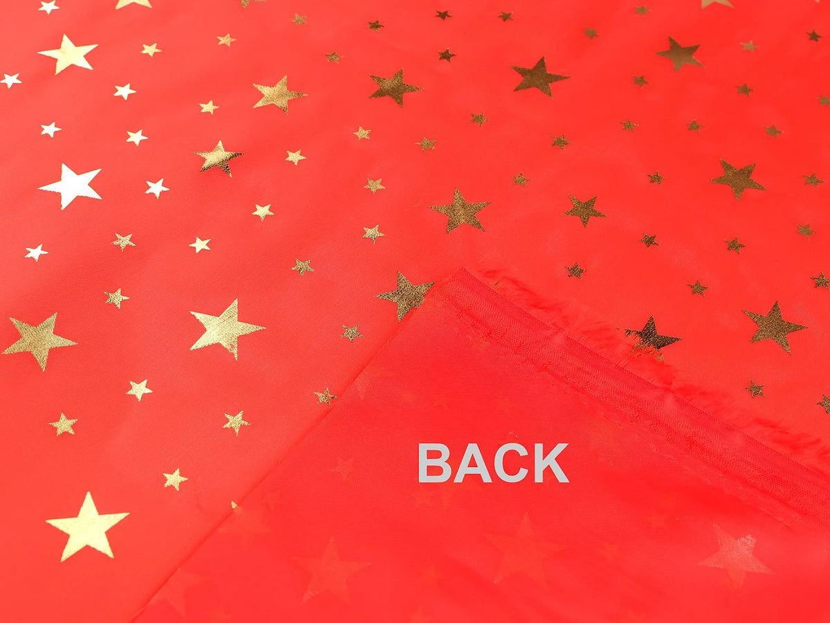 Image d'un tissu décoratif de Noël à étoiles dorées, disponible en ligne chez Šarlotes audumi