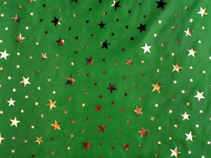 Image d’un tissu décoratif de Noël vert à étoiles dorées – disponible en ligne chez Charlotte Audumi