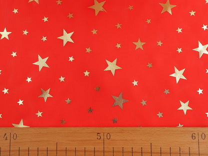 Image d’un tissu décoratif de Noël vert à étoiles dorées – disponible en ligne chez Charlotte Audumi